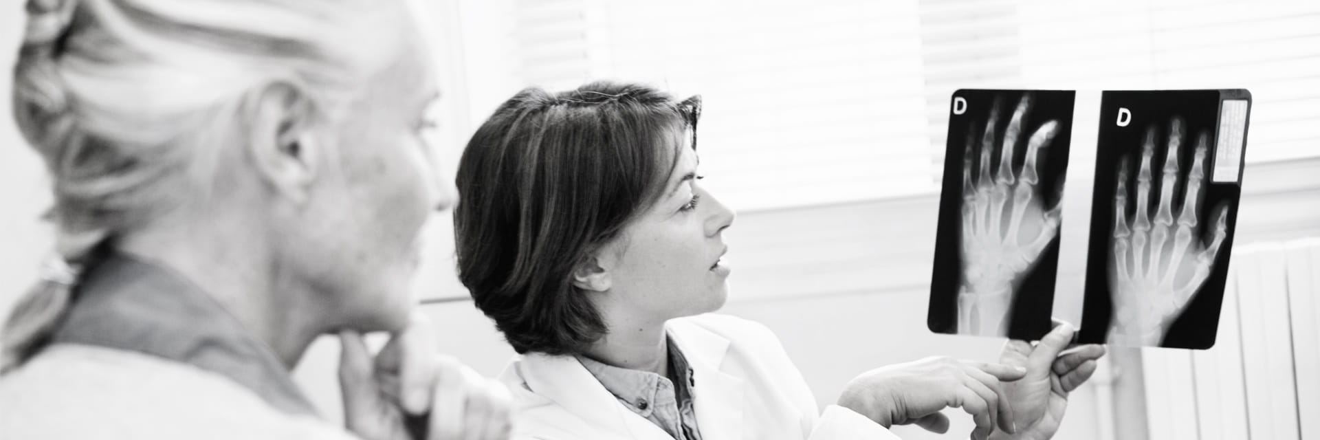 Rheumatologist examining scans of a hand with patient